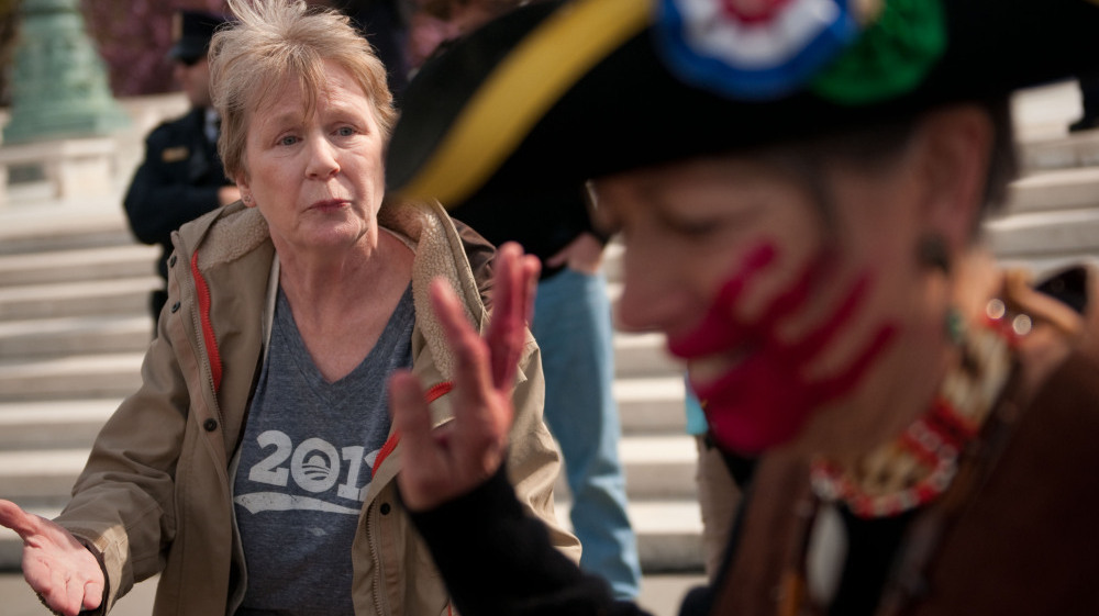 Holly Harness (left), a supporter of the health care law, argues with Susan Clark, an opponent of the law, outside the Supreme Court on Wednesday.