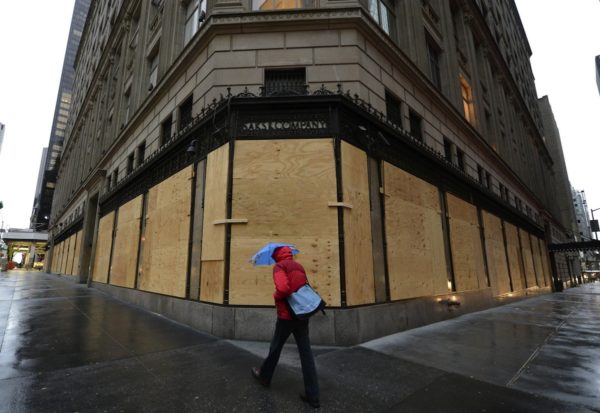 TOPSHOTS A woman walks past a boarded up Saks Fifth Avenue October 29, 2012 as New Yorkers prepare for Hurricane Sandy which is suppose to hit the city later tonight. Much of the eastern United States was in lockdown mode October 29, 2012 awaiting the arrival of a hurricane dubbed "Frankenstorm" that threatened to wreak havoc on the area with storm surges, driving rain and devastating winds. AFP PHOTO / TIMOTHY A. CLARY