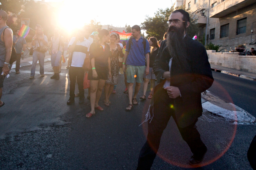 Ultra-Orthodox Jew Yishai Schlissel walks through a Gay Pride parade and is just about to pull a knife from under his coat and start stabbing people in Jerusalem Thursday, July 30, 2015. Schlissel was recently released from prison after serving a term for stabbing several people at a gay pride parade in 2005, a police spokeswoman said.(AP Photo/Sebastian Scheiner)