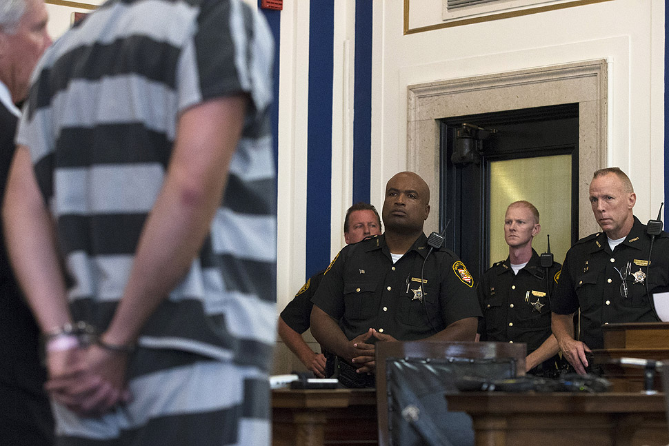 Court officers look on as former University of Cincinnati police officer Ray Tensing, left, appears at Hamilton County Courthouse for his arraignment in the shooting death of motorist Samuel DuBose. Tensing, who was indicted and fired from his job on Wednesday, shot and killed Dubose on July 19 after stopping him over a missing license plate.