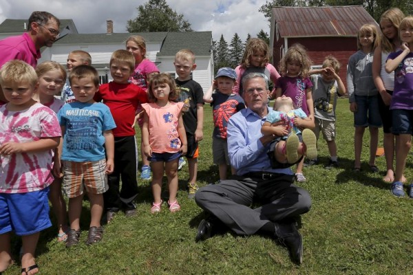 Republican presidential candidate Jeb Bush poses for a photograph with a group of day care children during a campaign stop in Lancaster, New Hampshire July 23, 2015. REUTERS/Brian Snyder