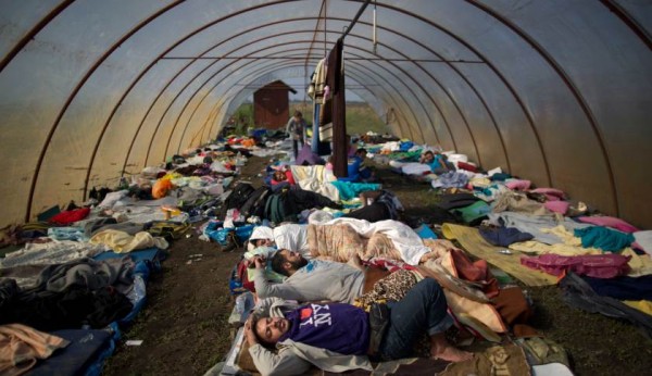 Syrian people sleep inside a greenhouse at a makeshift camp for asylum seekers near Roszke, southern Hungary, Sunday, Sept. 13, 2015. Hundreds of thousands of Syrian refugees and others are still making their way slowly across Europe, seeking shelter where they can, taking a bus or a train where one is available, walking where it isn't. (AP Photo/Muhammed Muheisen)