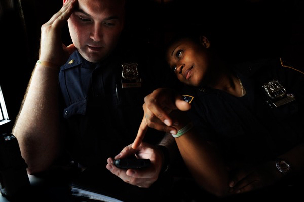 Officers Weadock, left, and Olivero spend their lunch break checking out the precinct gossip on Facebook. Oct. 8, 2009. Antonio Bolfo/Reportage by Getty Images.