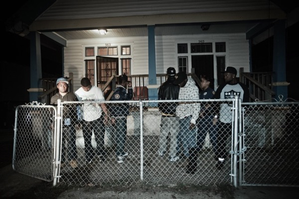 The young men stand in the yard as officers continue their weapons search. New Orleans. Julie Dermansky.