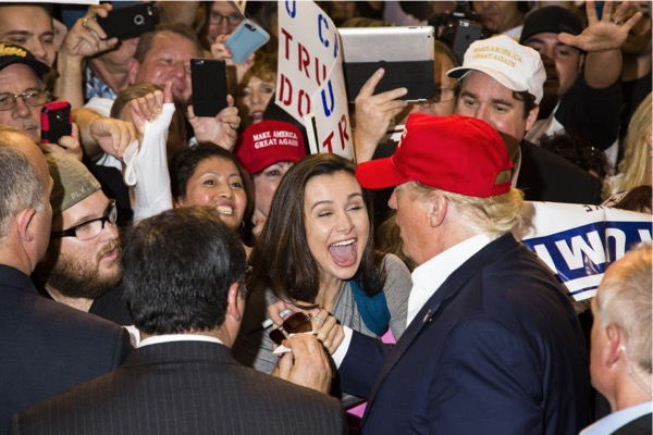 An audience member reacts to getting an autograph from Republican presidential candidate Donald Trump following his rally in Sarasota, Fla. Nov. 28, 2015.