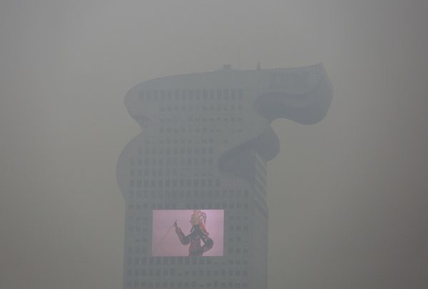 A building with a screen on it in Beijing on Tuesday was obscured by smog that led to the city’s top level of air pollution warning. Damir Sagolj/Reuters