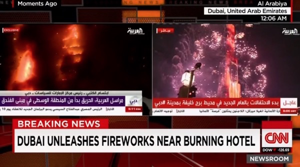A fire burns at the Address hotel in downtown Dubai as New Year's fireworks explode over the Burj Khalifa. CNN screenshot.