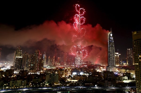 A fire burns at the Address hotel in downtown Dubai as New Year's fireworks explode over the Burj Khalifa