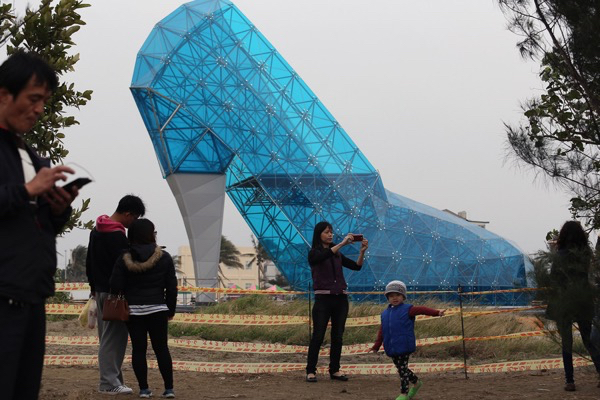 photo: AFP / Getty. caption: Tourists take pictures in front of a shoe-shaped church in southern Chiayi, Taiwan, on January 11, 2016. The church, which measures 55 feet tall and 36 feet wide, took two months to build. Members of the public will be able to visit the exterior of the church before it is officially opened on February 8, 2018, before the lunar new year.