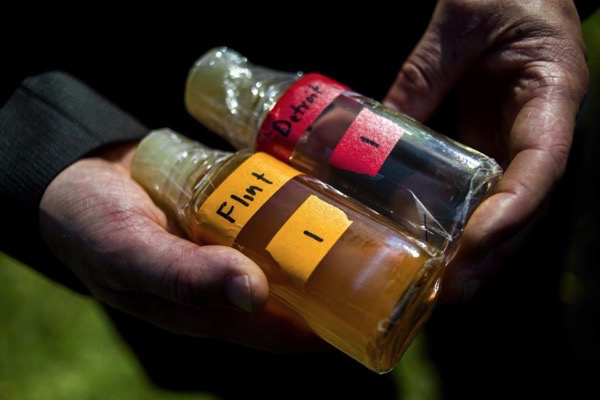 Virginia Tech professor Marc Edwards shows the difference in water between Detroit and Flint. Flint has faced a water contamination crisis since it switched water sources but did not treat the water to prevent lead, a potent neurotoxin, from leaching out of pipes.