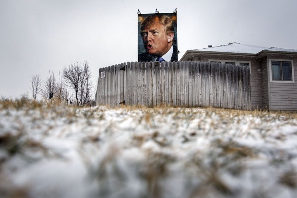 A giant poster of Donald Trump stands on display in the backyard of supporter George Davey's residence in West Des Moines, Iowa.