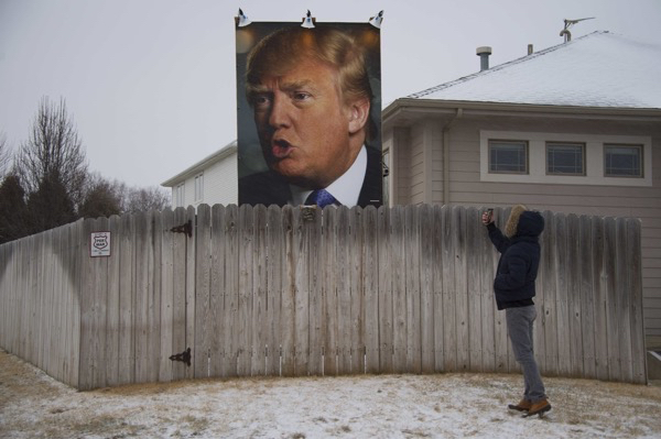 A giant poster of Donald Trump stands on display in the backyard of supporter George Davey's residence in West Des Moines, Iowa.