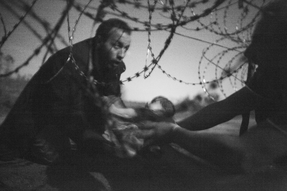 Winner of the 2015 World Press Photo award, migrants crossing the border from Serbia into Hungary.