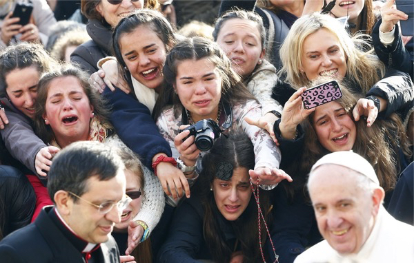 People greet Pope Francis as he arrives to lead the weekly audience in Saint Peter's Square at the Vatican, on January 27, 2016.