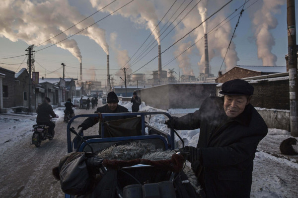Chinese men pull a tricycle in a neighborhood next to a coal-fired power plant in Shanxi, China. A history of heavy dependence on burning coal for energy has made China the source of nearly a third of the world’s total carbon dioxide (CO2) emissions, the toxic pollutants widely cited by scientists and environmentalists as the primary cause of global warming. World Press Winner.
