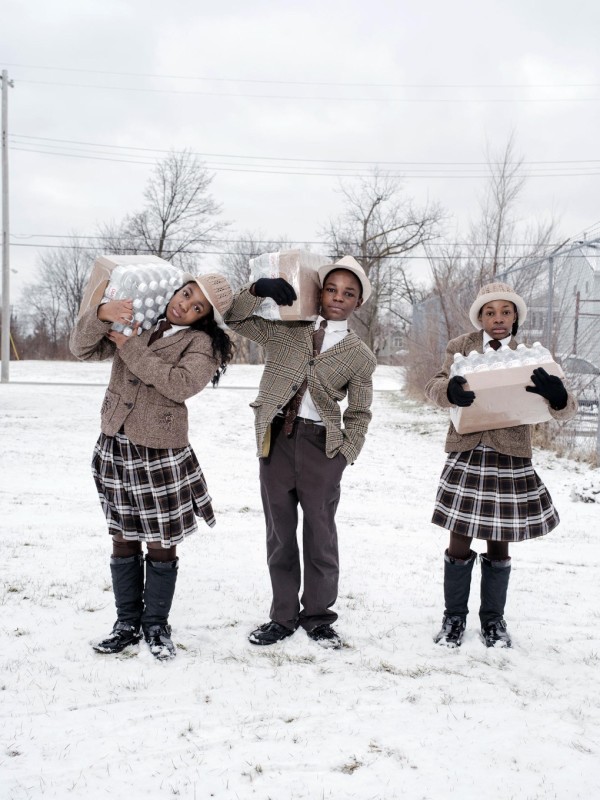 Siblings Julie, Antonio, and India Abram collect their daily allowance of bottled water from Fire Station #3. Located on Martin Luther King Avenue, it is one of five firehouses that have become water resource sites in Flint, Michigan.