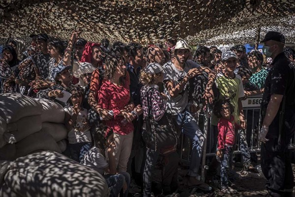 People wait in line for documents at the refugee processing center in Presevo, Serbia, Aug. 27, 2015. Countries like Greece, Macedonia and Serbia recognized that few if any of the migrants wanted to stay there, because the economic prospects in those countries were poor. So they came up with a system that gave the refugees the legal right to pass through the country, without necessarily applying for asylum. (Sergey Ponomarev/The New York Times)