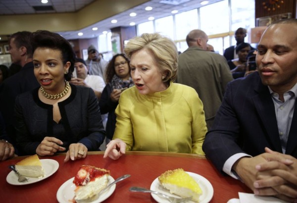 Democratic presidential candidate Hillary Clinton, center, talks with City Councilwoman Laurie Cumbo (D-Brooklyn) and Rep. Hakeem Jeffries (D-Brooklyn) as she looks over the cheesecake offerings at Junior's restaurant in Downtown Brooklyn on Saturday, April 9, 2016. (Credit: AP / Seth Wenig)