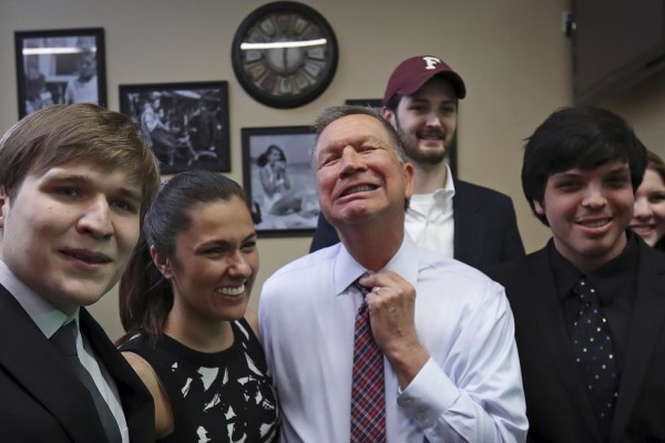 John Kasich adjusts his tie as he poses for a photo with supporters before a meet and greet at the Arthur Avenue Market in the Bronx. REUTERS/Carlo Allegri