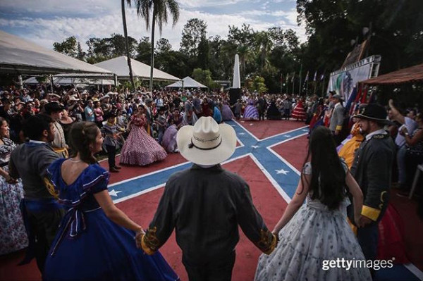 People in traditional outfits hold hands between dances at the annual Festa Confederada, or Confederate Party in Santa Barbara d'Oeste, Brazil. The festival is put on by Brazilian descendants of families who fled from the southern United States to Brazil during Reconstruction, between 1865 and 1875, following the end of the U.S. Civil War. Thousands attend the festival which is held at the American Cemetery, or Cemiterio dos Americanos, where graves of settlers and descendants remain to this day. The festival features traditional Southern-style dancing, music and cuisine. The U.S. settlers eventually assimilated with local Brazilians and some now are racially mixed while many others no longer speak English. Organizers say the festival represents familial tradition, ancestral heritage and happiness and is not associated with the negative connotations of the Confederacy. The flag carries no stigma or #political meaning in Brazil, April 24, 2016.