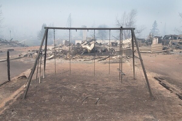 A swing set with the swings burned away sits in a residential neighborhood destroyed by a wildfire on May 6, 2016 in Fort McMurray, Alberta, Canada Wildfires, which are still burning out of control, have forced the evacuation of more than 80,000 residents from the town. Scott Olson/Getty Images.