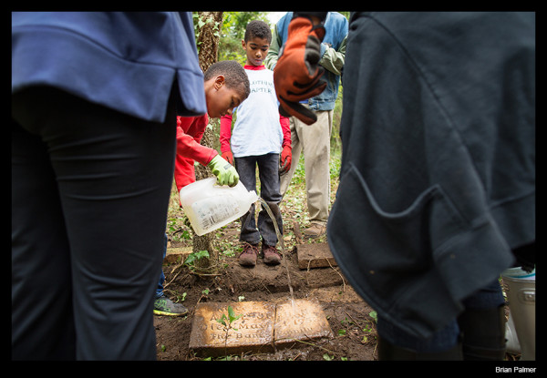 Youth from Jack and Jill rinse a grave marker they uncovered while volunteering at East End Cemetery, Henrico County, VA. October 2015