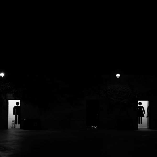 A photo of men's and woman's bathrooms across a dark expanse speaks to the current cultural battle in the United States over LGBTQ rights and who is allowed to use which. Jae Chong/Instagram.