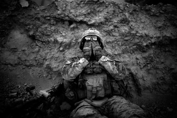 Photo: David Gilkey/NPR. Caption: Lance Cpl. Anthony Espinoza, Bravo Co. 1/5, wipes the salt and sweat out of his eyes which drips down out of his helmet at the end of a day long patrol out of Patrol Base Fires in Sangin District, Helmand province, Afghanistan on May 4, 2011. The 100 plus degree temperatures combined with the humidity of the flooded farm fields make walking and patrolling in the area a daily battle.