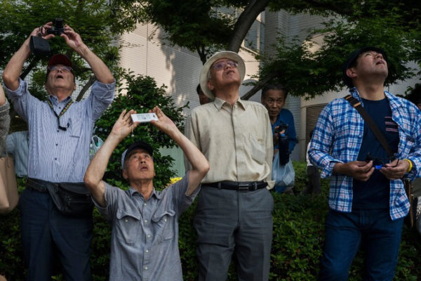 Photographing a helicopter along the route of President Obama's motorcade in Hiroshima, Japan, on Friday. Credit Adam Dean for The New York Times