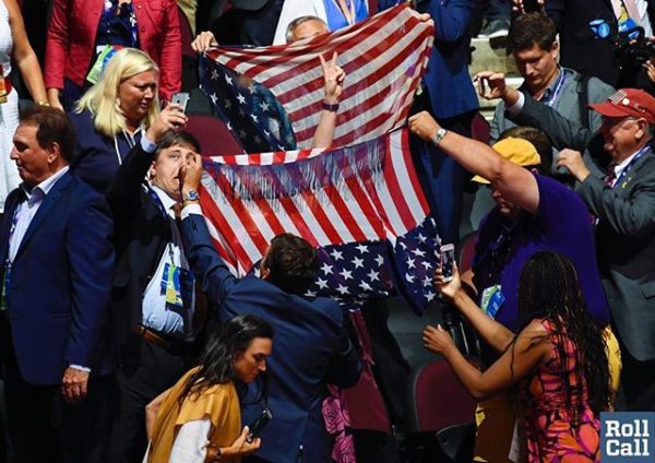 Guy takes a selfie with anti-Trump protester as other try to cover her with American flags at the RNC billclarkphotos