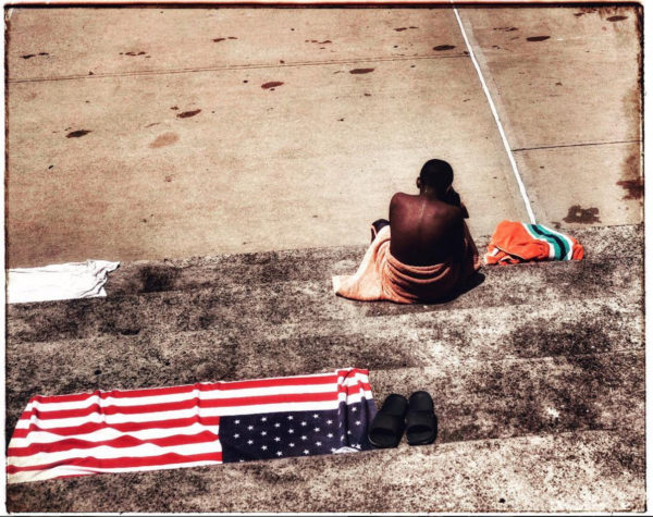 A teen takes a break from swimming at a pool in Queens. It's summer. Photo: Spencer Platt/Getty Images