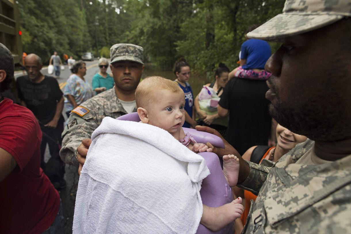 (Photo by Max Becherer/AP). caption. Louisiana Army National Guard members loading residents into trucks as they ran rescue operations on Sunday in Walker, Louisiana.