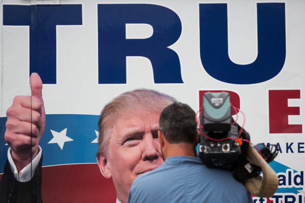 Photo: Damon Winter/The New York Times. Caption: A television cameraman filmed a mobile voter register booth outside a Donald J. Trump event in Tampa, Fla., on Wednesday.