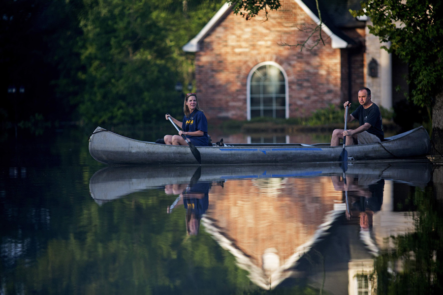 photo: Max Becherer / AP. caption: Danny and Alys Messenger canoe away from their flooded home after reviewing the damage in Prairieville, Louisiana, on August 16, 2016.