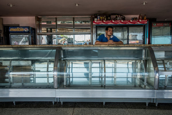 Photo: Meridith Kohut / New York Times. caption: Dionny Ramárez, 36, at the bakery in Boca de Uchire where he works. It was looted by hundreds of people on June 7. He said he grabbed the bakery’s Panini press, one of its most valuable items, to keep it safe.