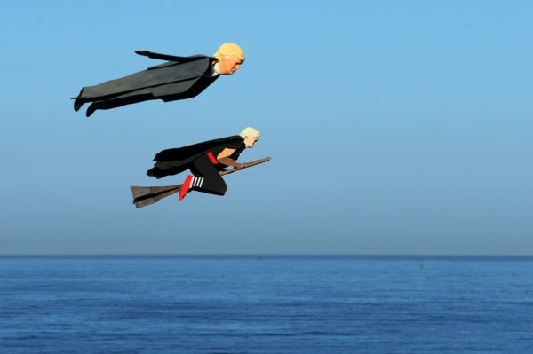 Remote control planes resembling U.S. Presidential candidate Donald Trump and Hillary Clinton fly over surfers in Carlsbad, California, U.S. September 15, 2016. REUTERS/Mike Blake - RTSNY10