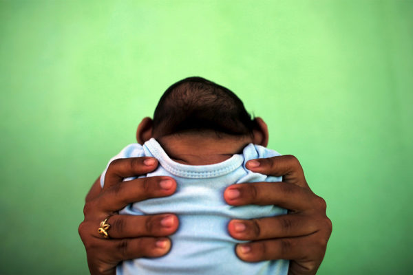 Jackeline, 26, holds her son who is 4-months old and born with microcephaly, in front of their house in Olinda, near Recife, Brazil, February 11, 2016. Photo: Nacho Doce/REUTERS.