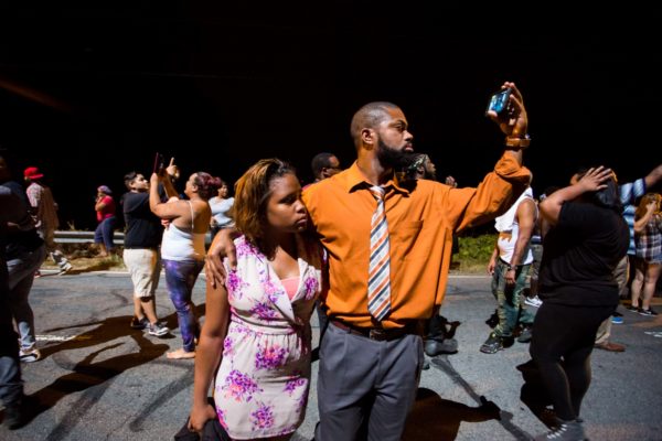 Protestors voiced frustrations to armored CMPD officers as they stand on Old Concord Road. Logan Cyrus/Charlotte Magazine