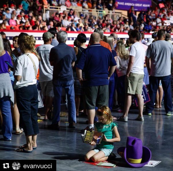 Seven year-old Hollie Hughes, of Riner, Va. looks at a book before a campaign rally with Republican presidential candidate Donald Trump in Roanoke, Va.