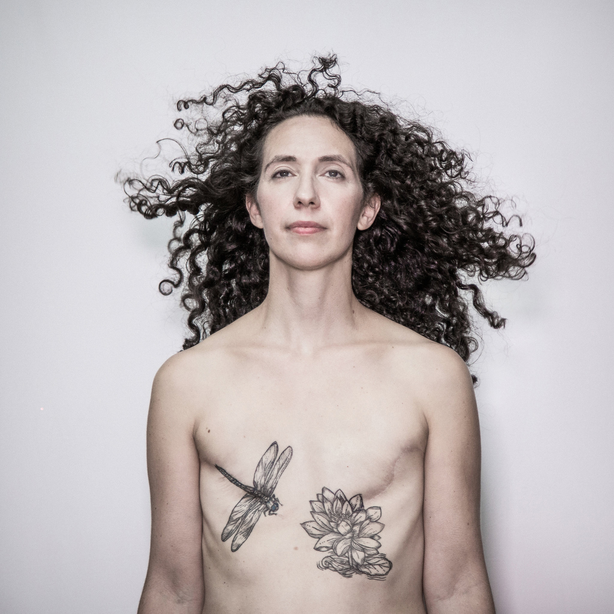 Photograph by Béatrice de Géa for The New York Times. Caption: “It’s a tremendous amount to put your body throgh, and it’s not like we’re going to get our breasts back,” said Rebecca Pine, 40, who decided against reconstruction surgery after a mastectomy. 