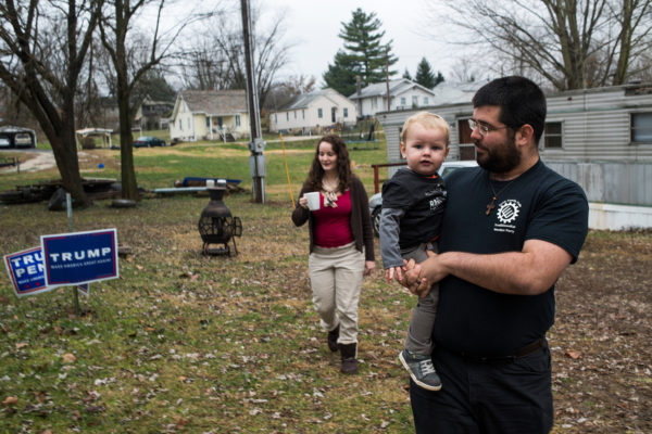 Matthew Heimbach, who runs the Traditionalist Worker Party, at home in Paoli, Ind., with his son and wife. His group advocates replacing the United States with nation-states based on ethnicity and religion. Credit Ty Wright for The New York Times