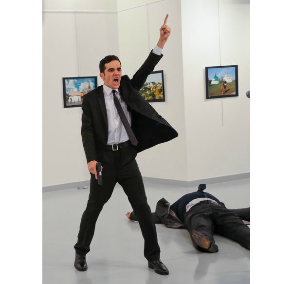 An unnamed gunman gestures after shooting the Russian Ambassador to Turkey, Andrei Karlov, at a photo gallery in Ankara, Turkey, Monday, Dec. 19, 2016. A gunman opened fire on Russia's ambassador to Turkey at a photo exhibition on Monday. The Russian foreign ministry spokeswoman said he was hospitalized with a gunshot wound. (AP Photo/Burhan Ozbilici)