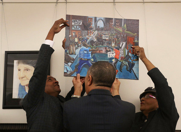 Rep. Cedric Richmond (D-LA), chairman Congressional Black Caucus, Rep. William Lacy Clay (D-MO) and Rep. Alma Adams (D-NC)(L-R) rehang a painting on the U.S. Capitol walls after it was removed by Rep. Duncan Hunter (R-CA) on Friday because he found it offensive on January 10, 2017 in Washington, DC. The painting is part of a larger art show hanging in the Capitol and is by a recent high school graduate, David Pulphus, from Clay's district and depicts his interpretation of civil unrest in and around the 2014 events in Ferguson, Missouri. (Jan. 9, 2017 - Source: Joe Raedle/Getty Images North America)