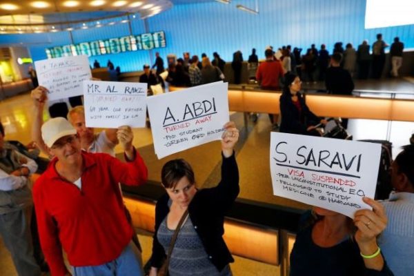 (photo: Patrick T. Fallon/Reuters. caption: People hold signs with the names of people detained and denied entry in protest of Donald Trump's travel ban at Los Angeles International Airport (LAX) in Los Angeles, California.)