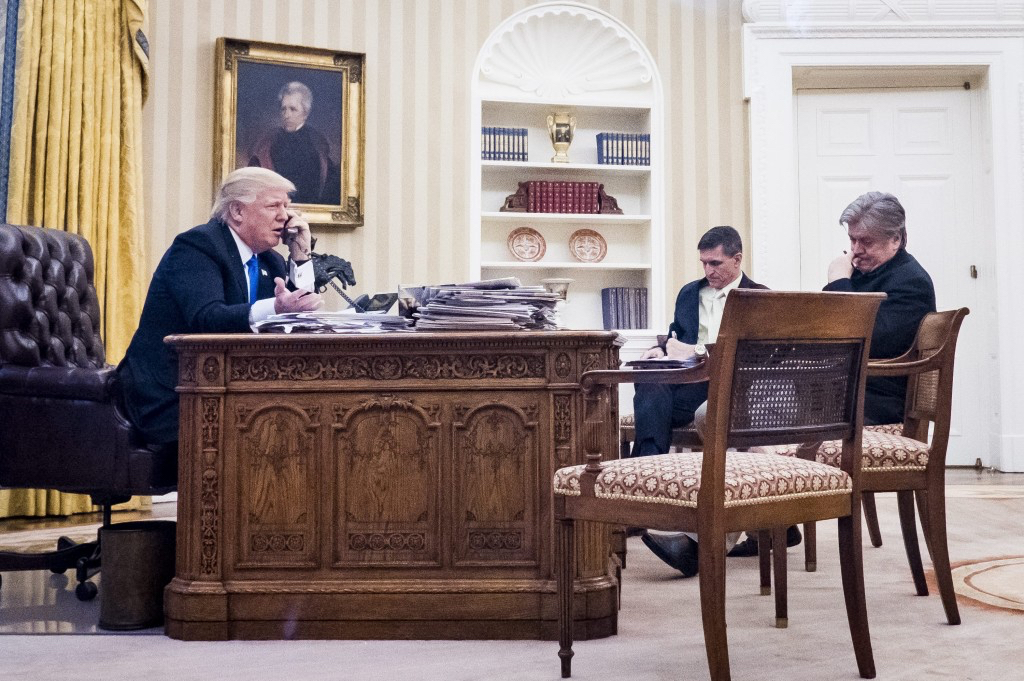 Al Drago for The New York Times. President Donald Trump speaks on the phone with Australian Prime Minister Malcolm Turnbull in the Oval Office of the White House, January 28, 2017 in Washington, DC. Also pictured at right, National Security Advisor Michael Flynn and White House Chief Strategist Steve Bannon. On Saturday, President Trump is making several phone calls with world leaders from Japan, Germany, Russia, France and Australia.