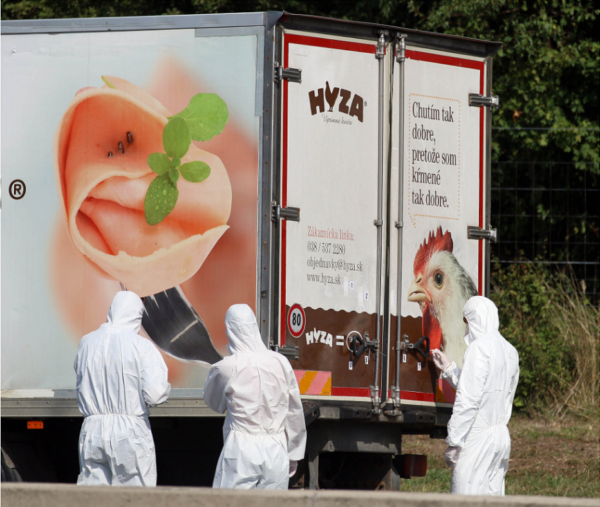 Figure 2 Officials inspect the truck abandoned on the side of an Austrian highway (Ronald Zak / AP)