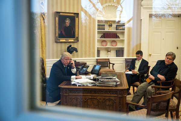 President Donald Trump speaks on the phone with Australian Prime Minister Malcolm Turnbull in the Oval Office of the White House, January 28, 2017 in Washington, DC. Also pictured at right, National Security Advisor Michael Flynn and White House Chief Strategist Steve Bannon. On Saturday, President Trump is making several phone calls with world leaders from Japan, Germany, Russia, France and Australia.<br>(Jan. 27, 2017 - Source: Drew Angerer/Getty Images