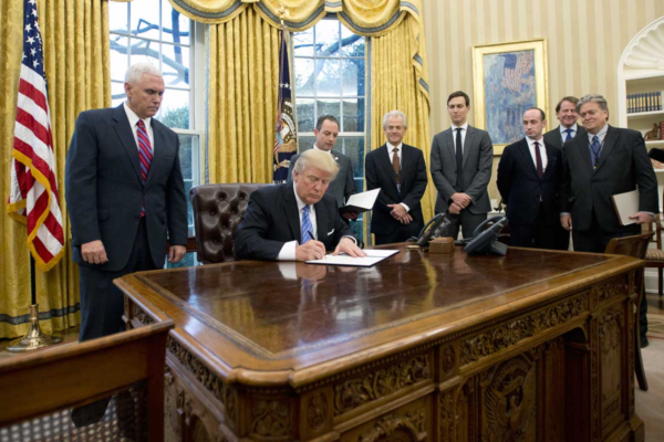 Ron Sachs /Pool photo via Bloomberg News, Trump signs executive actions in the Oval Office on Jan. 23, including one resurrecting a policy that prohibits foreign nongovernmental organizations that receive federal funding from performing or promoting abortion services through their work in other countries