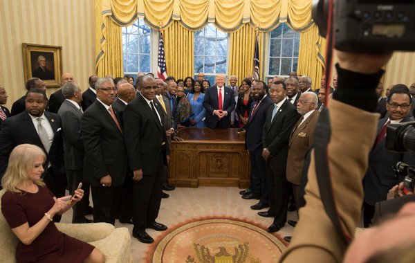Kellyanne Conway checked her phone on the couch while President Trump invited officials from historically black colleges and universities to join him in the Oval Office on Monday. STEPHEN CROWLEY / THE NEW YORK TIMES