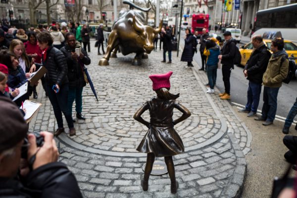 The “Fearless Girl” statue stands across from the iconic Wall Street “Charging Bull” statue, March 8, 2017, in New York City. (Credit: Business Insider)
